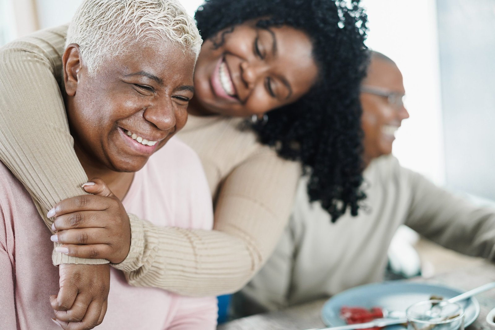African daughter hugging her mum during lunch meal at home – Lov African daughter hugging her mum during lunch meal at home - Love and family concept - Main focus on senior woman face